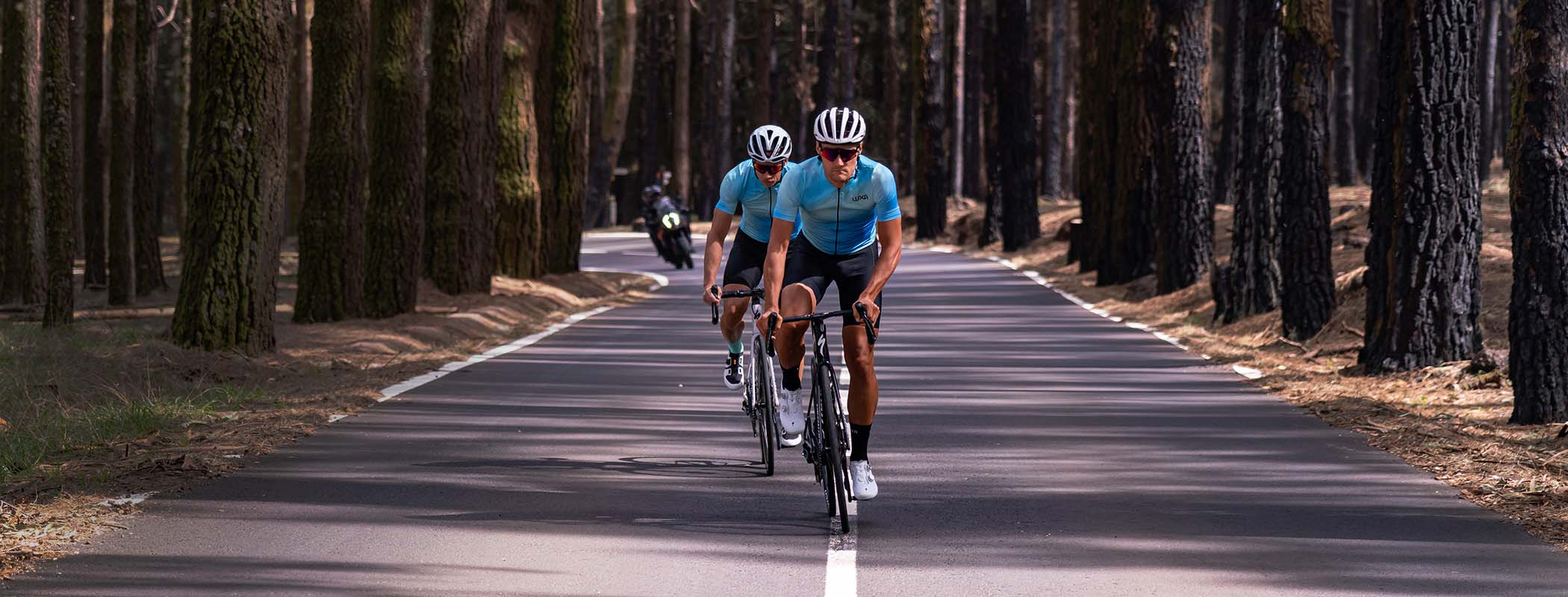 Szybko jadący kolarze po drodze na Teneryfie w błękitnych koszulkach rowerowych Luxa